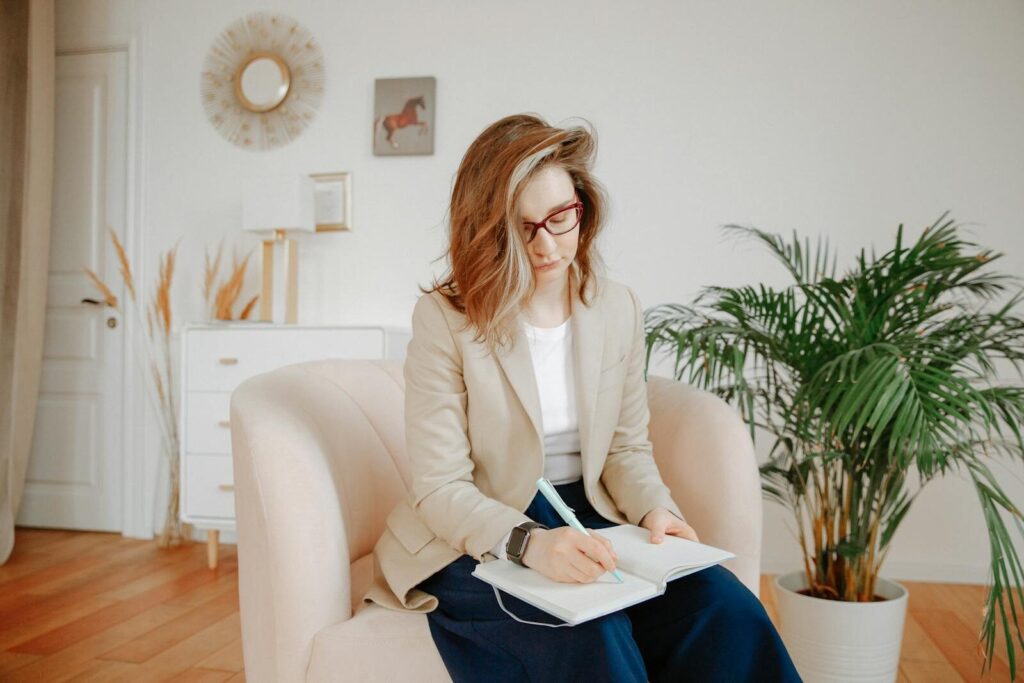 A female therapist taking notes during a session in a stylish office setting.