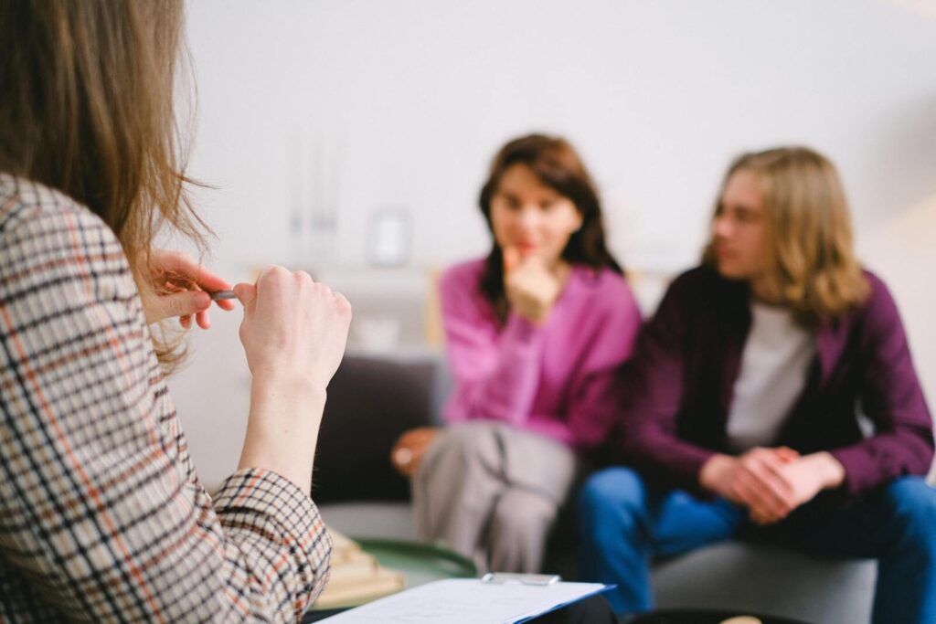 A couple in therapy, guided by a professional therapist in a calm setting.